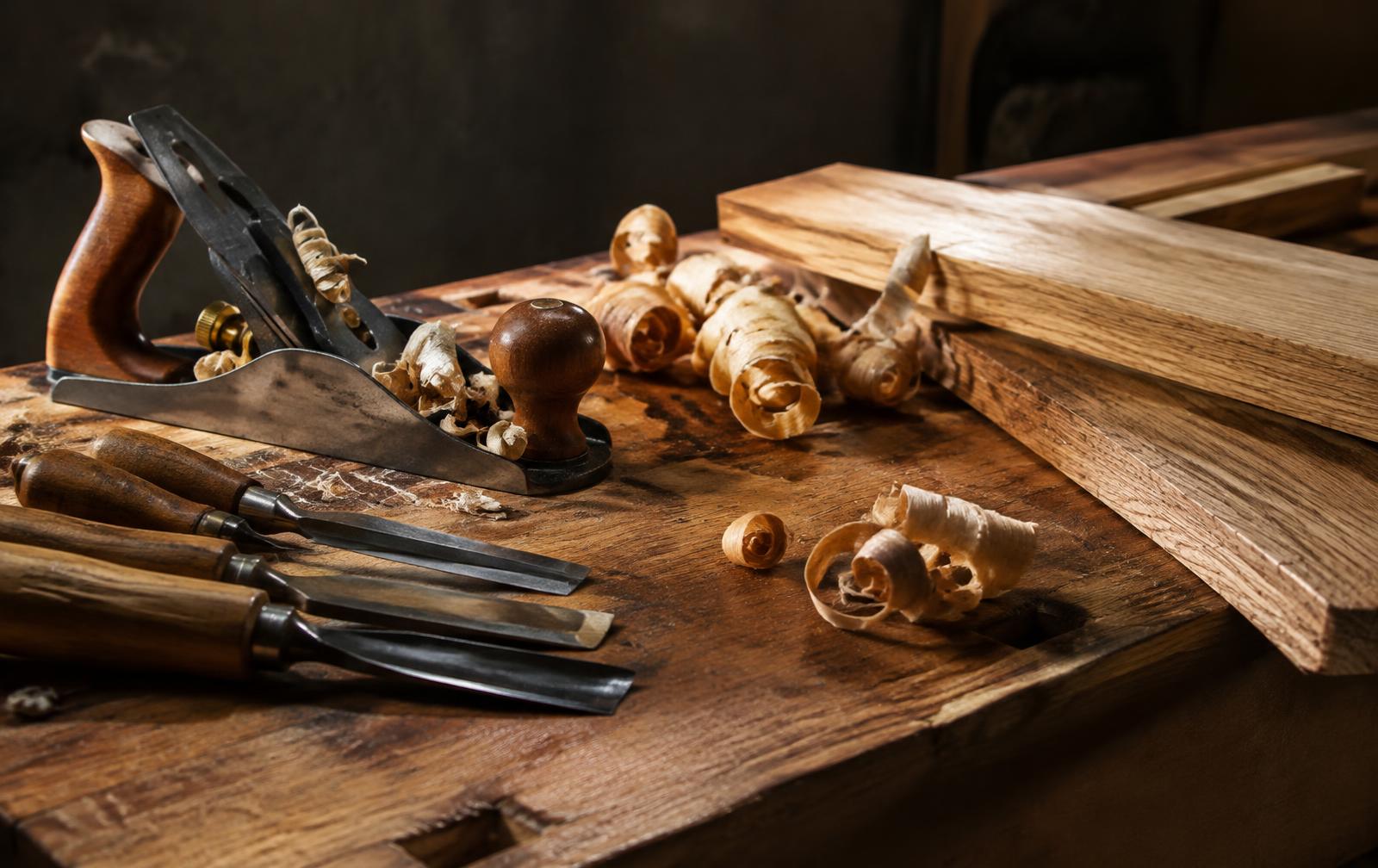 Hand plane, chisels and wood shavings on a workbench